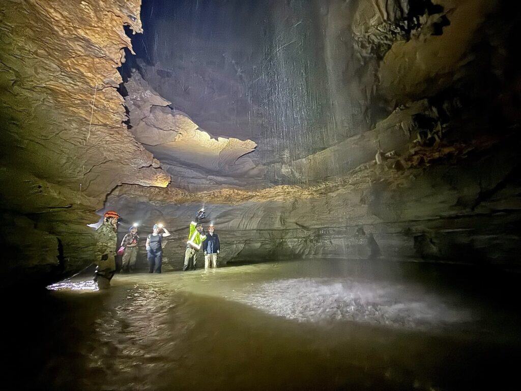 Cavers looking at a cave waterfall