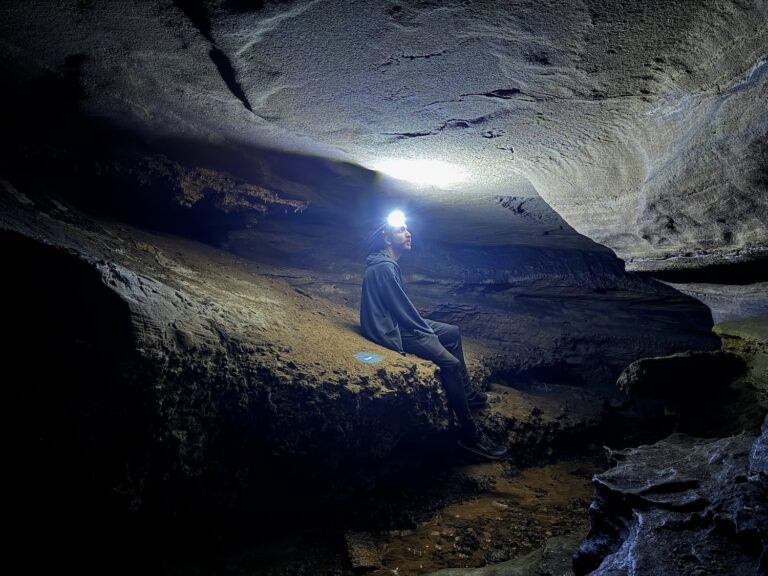 Mike resting on a ledge in a cave