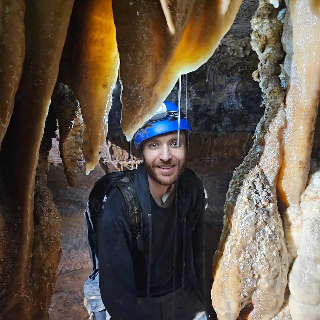 Mike In A Cave Mike smiling for a photo in a cave while being surrounded by cave formations